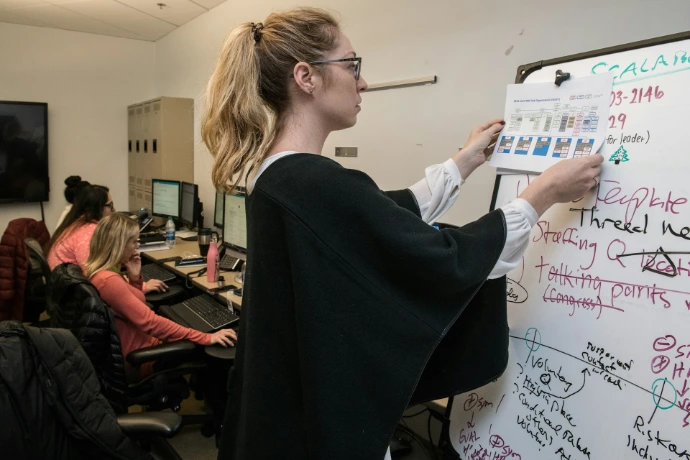 vrouw in zwarte blazer die op wit papier schrijft